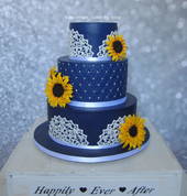 A 3 Tier Wedding Cake with quilting, edible lace and handmade sunflowers.