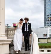 bride and groom walking down steps with flowers